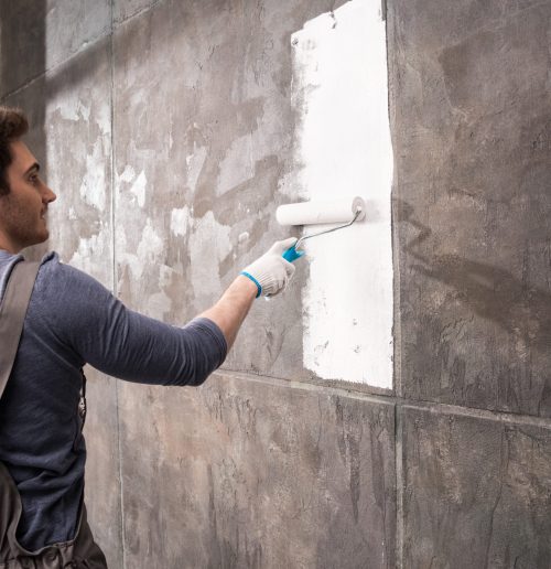 young man painting wall, renovation home concept